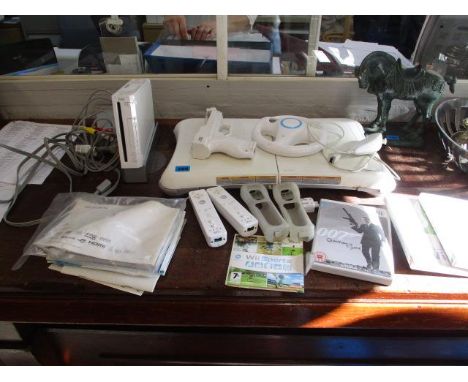 A Wii Console together with Wii Fit, Mario Kart and accessories (not tested) 
