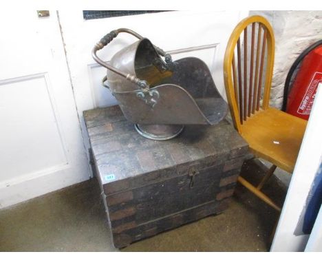 A metal bound trunk on wheels together with a copper coal scuttle 
