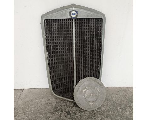 A Lancia radiator surround, the enamel badge with slight loss, approx. 46 cm wide, and a Lancia hubcap (2)Chrome badly pitted