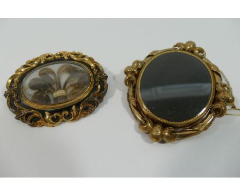 A Victorian hollow gold and black enamel oval mourning brooch, with hair panel and inscription to the verso dated 1853, 56mm 