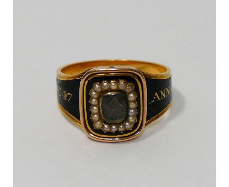 A George III gold, black enamel and seed pearl set mourning ring, with hair panel, the inscription running around the outside