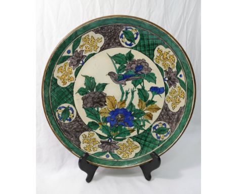 A Japanese porcelain charger, decorated in green, yellow, blue and grey with double boarder, the centre with bird amongst flo