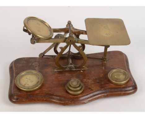 A set of Victorian brass post office scales, with weights, height 12cm, width 25cm.