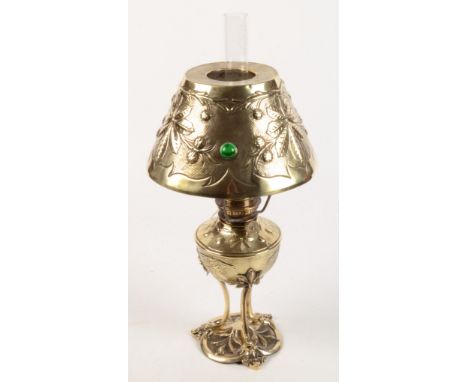 An Arts and Crafts brass oil lamp, the shade set with hardstones amongst foliage, height including chimney 52cm.  Condition r