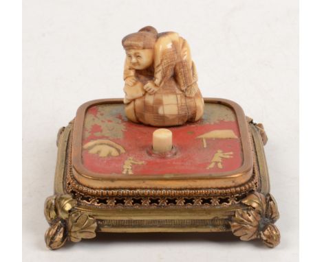 A gilt metal bell push surmounted with a netsuke, late 19th century, height 5.5cm, width 8.5cm.