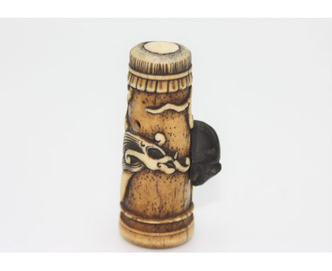 A bone netsuke carved as a dragon drum with a wooden rat, early 20th century, height 4.9cm, width 2.9cm.