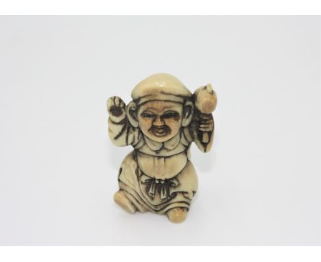 A ivory netsuke carved as a man with a mallet, early 20th century, height 4.6cm, width 2.6cm.