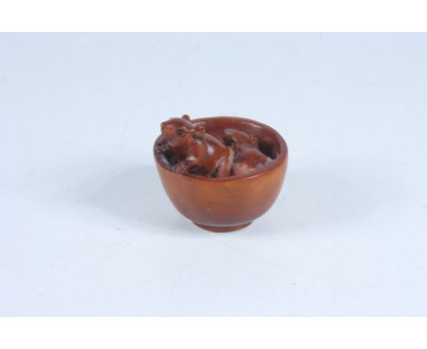 A Japanese carved wood netsuke in the form of rats in a bowl, signed, height 4cm, diameter 4.5cm.