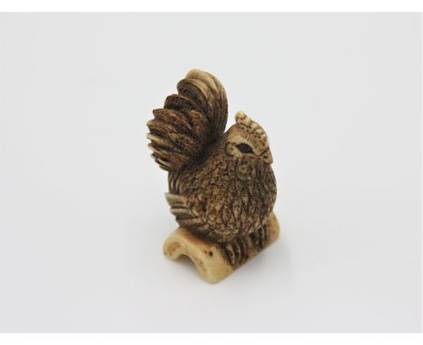 A bone netsuke carved as a hen, early 20th century, height 4.3cm, width 2.4cm.