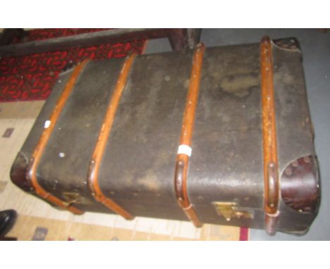 A leather and wood bound canvas trunk, height 33cm, width 83cm, depth 54cm. 