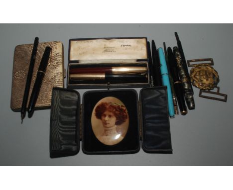 Fountain and other pens, a portrait, a naval two part buckle and a snake skin purse.