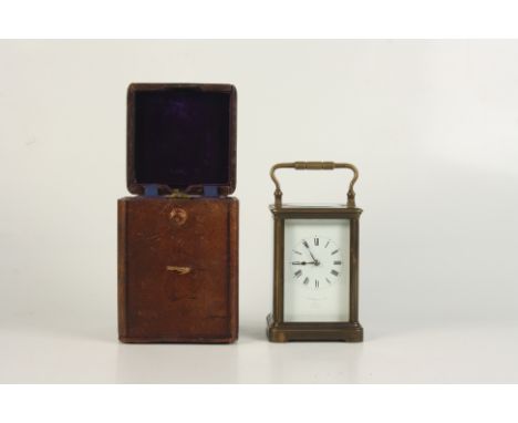 A brass carriage clock, the white enamelled dial inscribed 'F. P. Moore &amp; Co, Dublin'. Paris Make, with leather travellin
