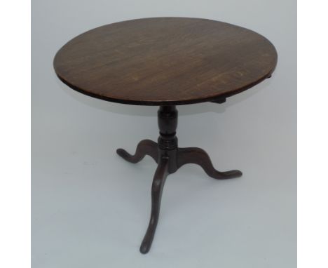 A George III oak snap top table, with tripod base and vase turned pedestal, diameter 84cm.