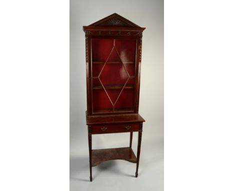 A mahogany display cabinet in Georgian style, with architectural carved pediment and glazed door, on a stand with a single dr