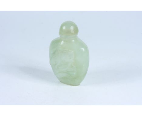 A jade snuff bottle carved with hares and pak choi rabbits, height 9cm. 