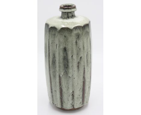 Attributed to David Leach, a tall cut sided stoneware vase with narrow neck, covered with a running speckled greenish glaze b