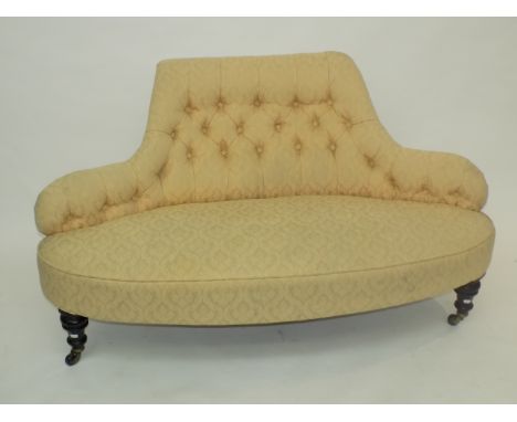 A Victorian shaped occasional button back sofa, with turned ebonised legs.