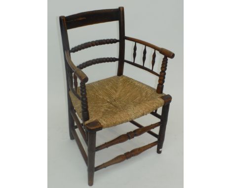 A 19th century William Morris style armchair with woven grass seat, bobbin turned horizontal splats and simulated bamboo legs