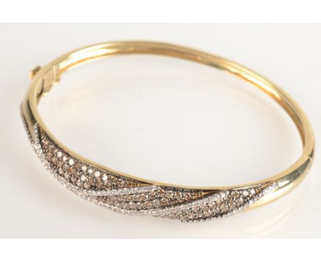 A 9ct gold modern French bangle set with white and champagne diamonds, 17.7g.