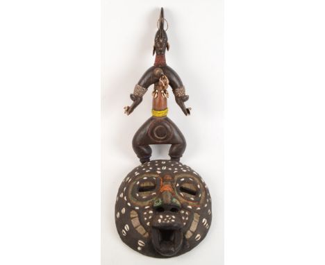 An African tribal wooden mask, decorated with shells, beadwork and brass, 38 x 34cm, and a tribal figure, height 61cm. 