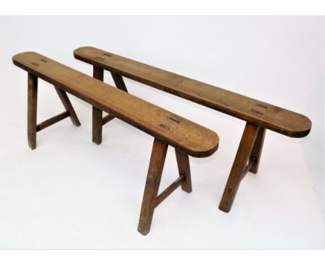A pair of elm benches, late 19th century, two legs on one bench are later oak replacements, height 46.5cm, width 131cm.