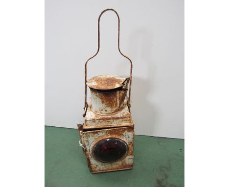 A white painted railway tail lamp with red bullseye lens, reservoir and burner