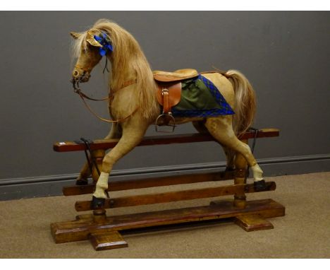 19th century tan and white pony skin covered rocking horse, bridle, saddle and stirrups, trestle base, L120cm Condition Repor