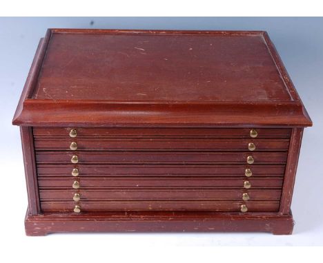 A teak coin collectors chest, having a cavetto moulded top above six drawers on a plinth base, each drawer containing various