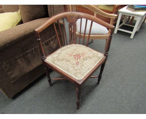 An Edwardian mahogany corner chair with inlaid details including central marquetry panel, "X" stretcher support and turned le