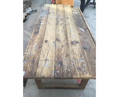 A LARGE WOODEN WORK BENCH/TABLE 244CM X 88CM (CORNER MISSING) 