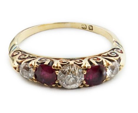 A late Victorian gold, three stone diamond and two stone ruby set half hoop ring, with carved setting, size M, gross weight 3