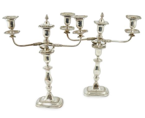 A pair of Elizabeth II silver two branch two light candelabra, by James Dixon &amp; Sons, with scroll arms and waisted knoppe