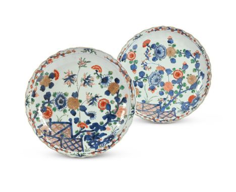 A pair of Chinese Famille Verte saucer dishes, Kangxi, with petal-shaped gilt rims, the centre of each painted in the Imari s