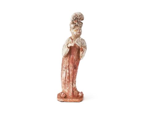 A Chinese painted terracotta figure of a lady, Tang dynasty, holding a fan in her left hand, a bird resting on her right, on 