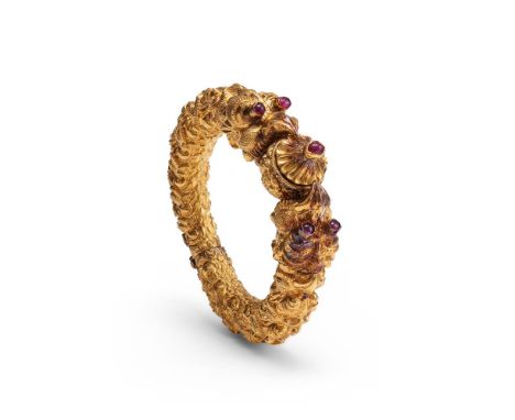 A gold bangle composed of kirtimukha faces, South Indian, 19th century, culminating in two facing makara heads, the eyes inla