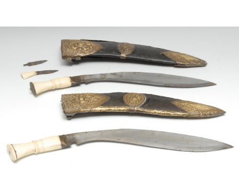 A Nepalese kukri, 30.5cm blade, bone grip, brass mounted leather scabbard, 43cm longoverall; another, similar (2) 