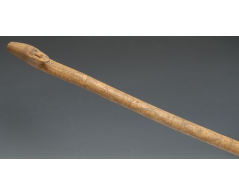 An Eastern staff or walking stick, probably Turkish, the pommel carved as a man wearing a fez, profusely decorated overall in