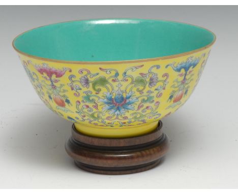 A Chinese circular bowl, brightly painted in polychrome enamels with lotus scrolls and precious objects on a yellow ground, t