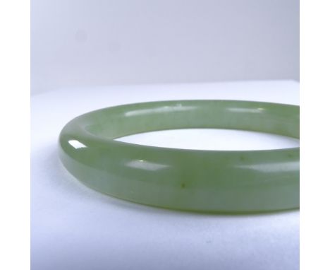 A polished jade slave bangle, band width 10mm, internal diameter 59mm, 36.8gExcellent original condition, no damage or repair