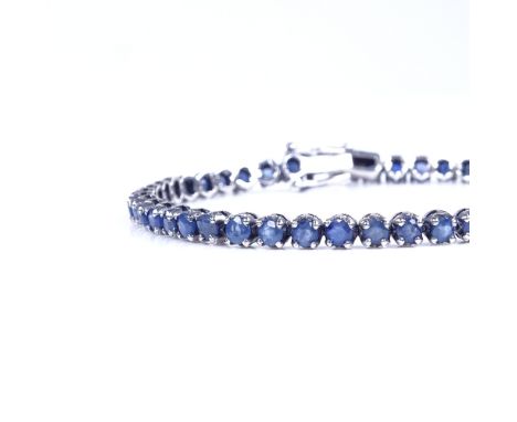 A modern sterling silver sapphire tennis line bracelet, bracelet length 19cm, 10.4gGood overall condition, all stones present