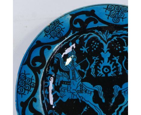An Islamic blue ground glazed pottery bowl, decorated with hunting scenes, diameter 30cm 
