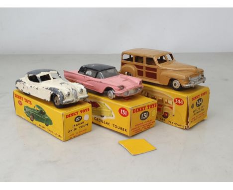 A boxed Dinky Toys No.157 white Jaguar XK120, P, box Ex, a boxed No.322 Estate Car, G, box Ex and a boxed No.131 pink Cadilla