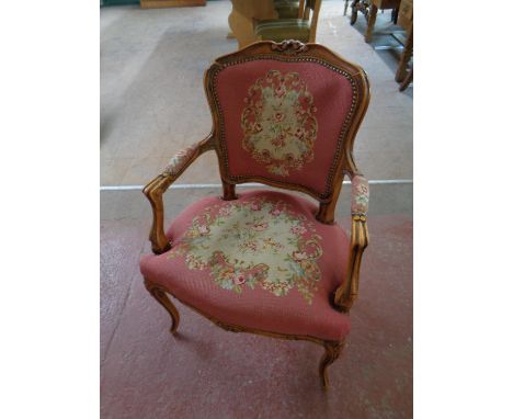 A carved beech framed French salon armchair upholstered in a tapestry fabric (damaged) 