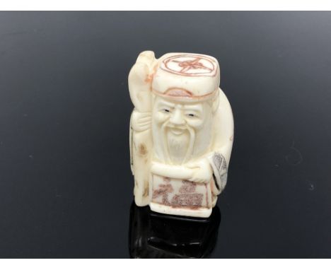 A carved hardwood netsuke  - Village elder with staff and scroll