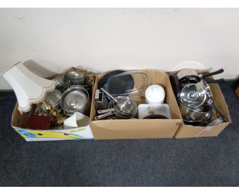 Three boxes containing kitchen utensils, pans, storage jars, candles, brass table lamp with shade, together with a brass fram