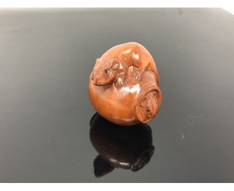 A carved hardwood netsuke  - Rats playing in a pot
