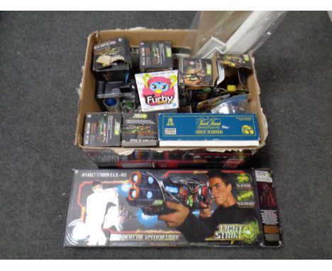 A box containing assorted toys to include Light Strike gun and launch systems, Furby, Trivial Pursuit 