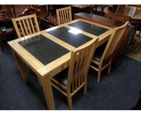 A contemporary pine dining table with three travertine tile inset panels together with a set of four rail back chairs   