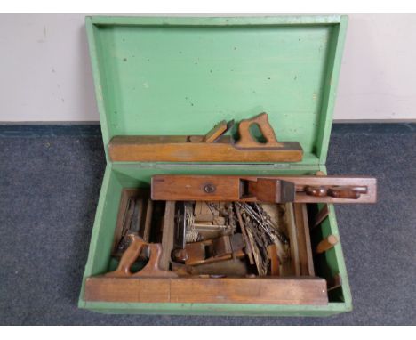 A 20th century painted pine box containing a quantity of vintage woodworking tools to include block planes, hand planes, etc 