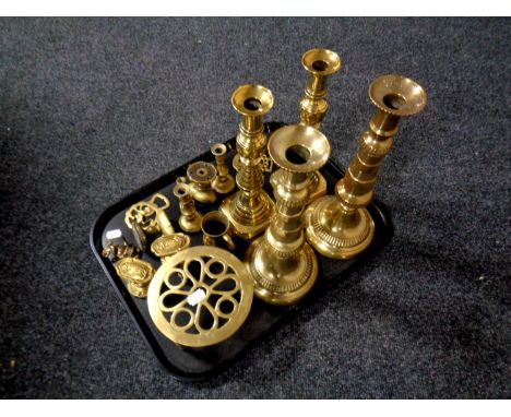 A tray of assorted brass ware to include antique brass candlestick, door handles, horse brasses, trivet etc 